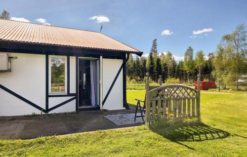 a small white house with a wooden gate in a field at 2 Bedroom Beautiful Apartment In Floda in Floda