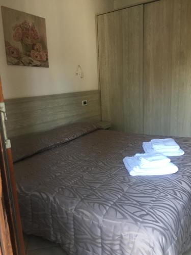 Le Corti Del Lago في بادينغي سول غاردا: غرفة نوم عليها سرير وفوط