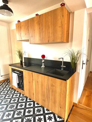 une cuisine avec un évier et un plan de travail noir dans l'établissement Appartement T3 vue sur mer, au Havre