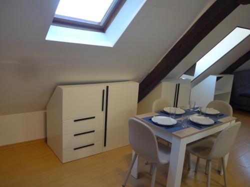 d'une salle à manger avec une table, des chaises et une lucarne. dans l'établissement Studio 38m2 centre-ville, à Bourges