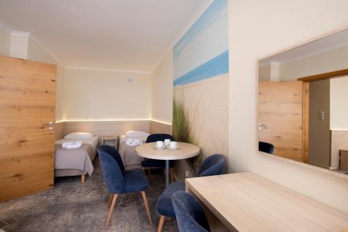 a restaurant with tables and chairs and a mirror at Interferie Cechsztyn in Ustronie Morskie