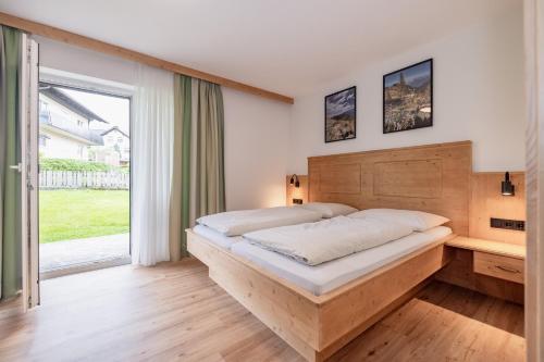 a bedroom with a bed and a large window at Gasthof - Pension Durnthaler in Tröpolach