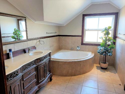 a large bathroom with a tub and a sink at 3 Rawdons Estate in Nottingham Road