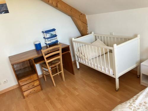 une chambre avec deux berceaux, un bureau et une table avec une chaise dans l'établissement Magnifique maison de vacances vue sur le lac, à Montperreux