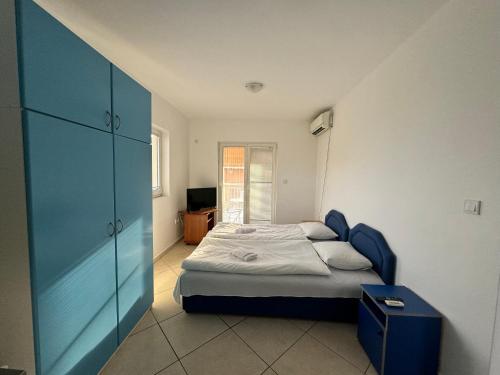 1 dormitorio con 1 cama y armario azul en Prijevor Apartments, en Budva