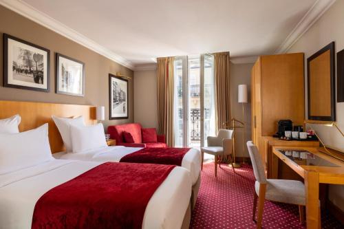 Pokój hotelowy z 2 łóżkami i biurkiem w obiekcie Royal Saint Michel w Paryżu