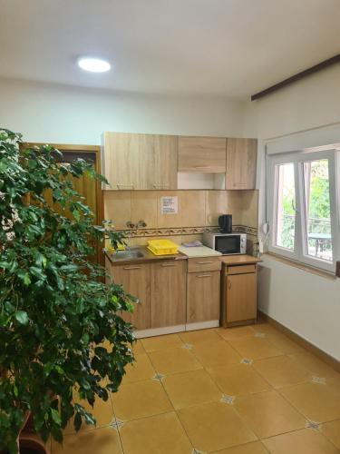 a kitchen with wooden cabinets and a tile floor at Sobe Nedović in Budva