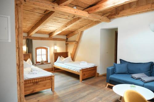 ein Wohnzimmer mit einer blauen Couch und einem Bett in der Unterkunft Mühle Tornow am Wentowsee in Tornow