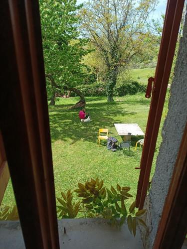 a window view of a yard with a table and chairs at Pilgrim Rooms in Gubbio