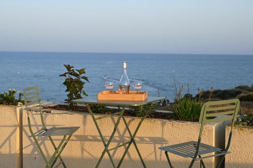 a table with two chairs and a bottle and wine glasses at Hôtel Bellevue Cap d'Agde in Cap d'Agde