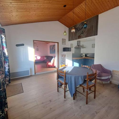 une chambre avec une table et des chaises ainsi qu'un salon dans l'établissement Maison de pêcheur au calme, à Bretignolles-sur-Mer