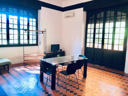 a table and chairs in a room with windows at Villa I Tigli Appartamenti in Campiglia Marittima