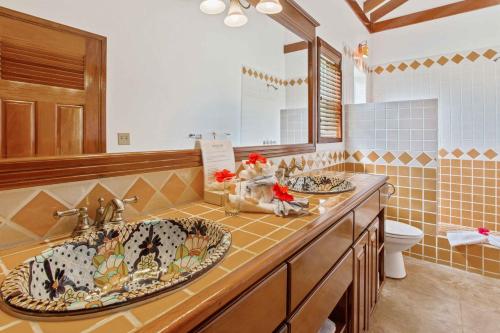 a bathroom with two sinks and a toilet at Hopkins Bay Belize a Muy'Ono Resort in Hopkins