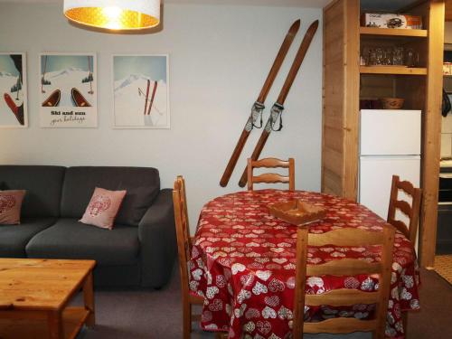un salon avec une table et un canapé et des skis au mur dans l'établissement Appartement accueillant pour 6 personnes au cœur des Orres - FR-1-322-18, aux Orres