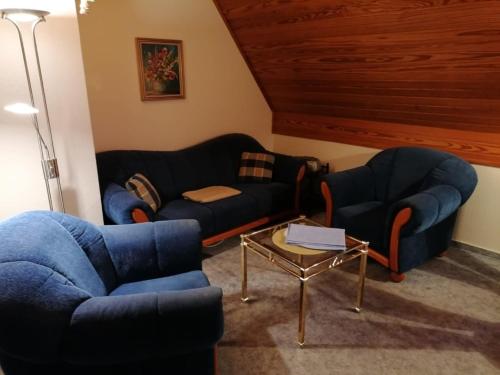 a living room with two blue couches and a table at Kampweg 1 Wohnung 1 in Cuxhaven