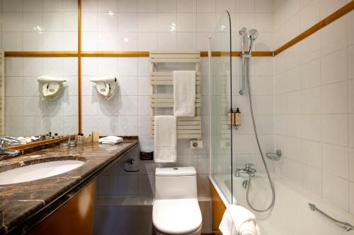 een badkamer met een douche, een toilet en een wastafel bij Royal Saint Michel in Parijs