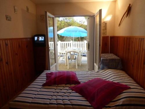 - une chambre avec un lit, un parasol et une terrasse dans l'établissement Studio cosy avec terrasse et garage, à 100m de la plage - Saint-Hilaire-de-Riez - FR-1-224-27, à Saint-Hilaire-de-Riez