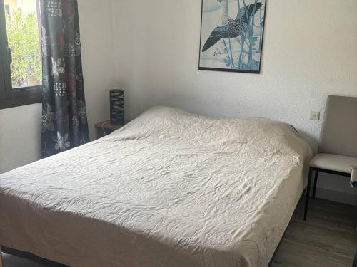 - un lit dans une chambre avec une fenêtre et une chaise dans l'établissement Maison T2 face mer avec parking privé, 4 couchages - FR-1-81-48, à Port-Leucate