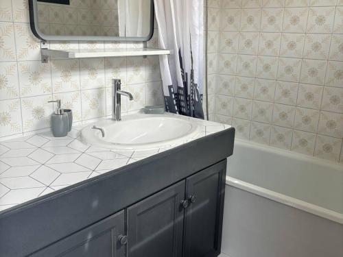 une salle de bain avec un lavabo, un miroir et une baignoire dans l'établissement Maison T2 face mer avec parking privé, 4 couchages - FR-1-81-48, à Port-Leucate