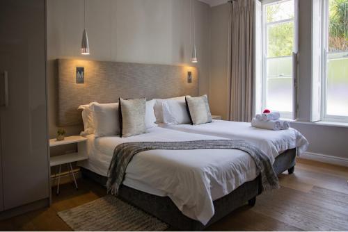 - une chambre avec 2 lits et une grande fenêtre dans l'établissement Macaron Boutique Guest House, à Franschhoek