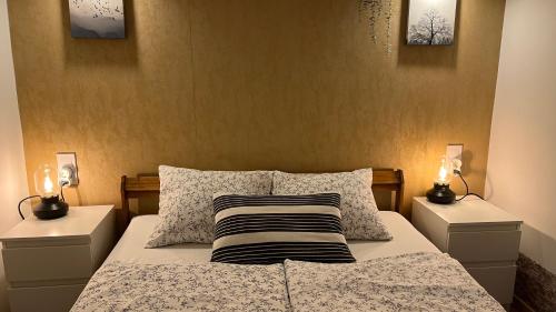um quarto com uma cama com 2 mesas de cabeceira e 2 candeeiros em M&M Apartment Budapest House em Budapeste