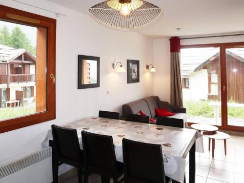 un salon avec une table et un canapé dans l'établissement Chalet mitoyen aux Orres 1800 avec piscine, sauna, hammam, parking et prestations incluses - FR-1-322-102, aux Orres