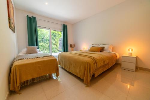 um quarto com 2 camas e uma janela em Villa Mirage em Aroeira
