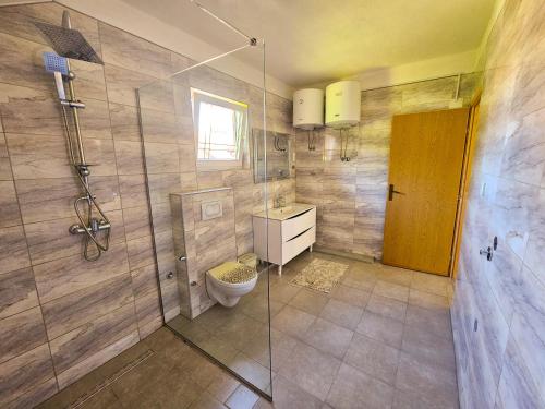 a bathroom with a toilet and a glass shower at Apartment Bijela ladja in Bihać