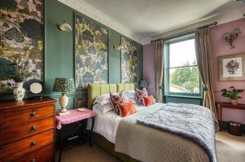 a bedroom with a bed and a dresser and a window at Hill House in Bath