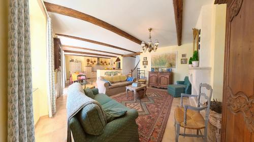 un salon avec un canapé vert et des chaises dans l'établissement Bijou- Charming Traditional Home with Pool in Minervois, à Saint-Jean-de-Minervois