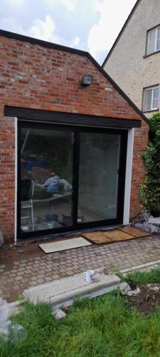 una gran ventana de cristal en una casa de ladrillo en Alivio - Thuiskomen bij jezelf op vakantie, en Lummen