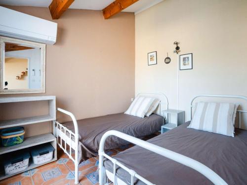 Cette chambre comprend 2 lits et un miroir. dans l'établissement Pavillon climatisé avec piscine, parking à Narbonne-Plage - FR-1-409-203, à Narbonne