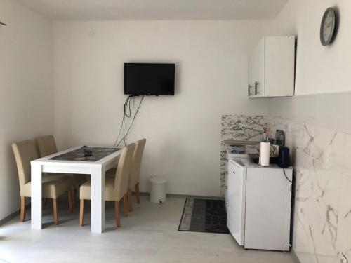 uma cozinha com uma mesa branca e um frigorífico branco em Apartman DB em Višegrad
