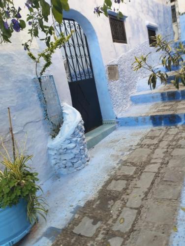 a blue and white building with a door at Dar Al Mansoura RIAD in Chefchaouene