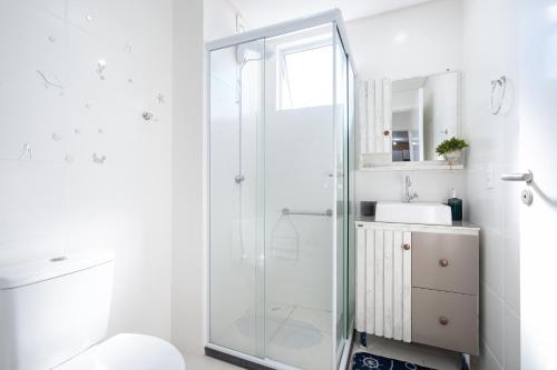 a bathroom with a glass shower and a sink at Apartamentos em Bal Piçarras 150 M DA PRAIA com SACADA, WI-FI, PISCINA, PORTARIA 24h, PLAYGROUND e vaga de GARAGEM in Piçarras