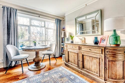salon ze stołem, krzesłami i lustrem w obiekcie Comfortable Home in Wandsworth by UndertheDoormat w Londynie