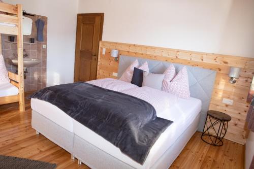 1 dormitorio con 1 cama blanca grande y cabecero de madera en Haus Lindbichl, en Sankt Johann im Pongau