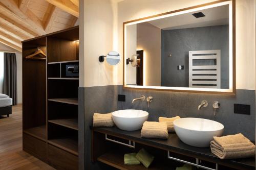 two sinks in a bathroom with a mirror at Camino Rustic Chic Hotel in Livigno
