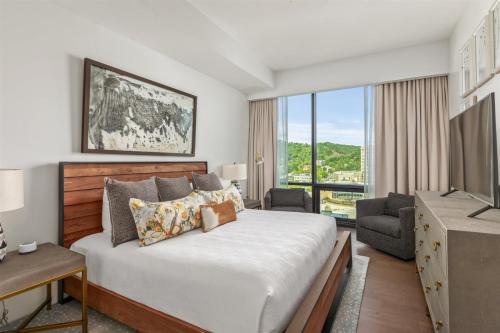 a bedroom with a large bed and a television at 'The Views Over Pack Square Park' A Luxury Downtown Condo with Mountain and City Views at Arras Vacation Rentals in Asheville