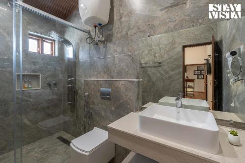 a bathroom with a sink and a shower and a toilet at StayVista at Greenwood Bungalow - Indoor & Outdoor Game in Ooty