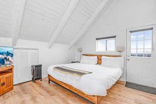 a white bedroom with a large bed and a window at Tidal House 2 in Ocean Shores