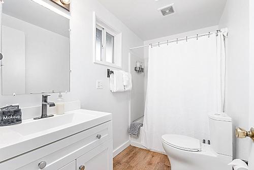 Baño blanco con lavabo y aseo en Tidal House 2 en Ocean Shores
