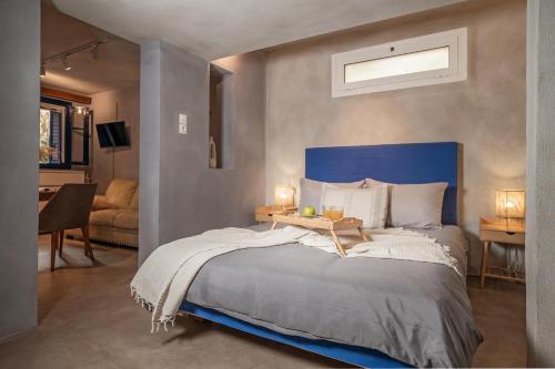 una camera con un grande letto con testiera blu di Mia Nonna 1 Bedroom House a Città di Zante