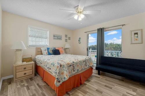 a bedroom with a bed and a window with a balcony at Bellas Beach House in Panama City Beach