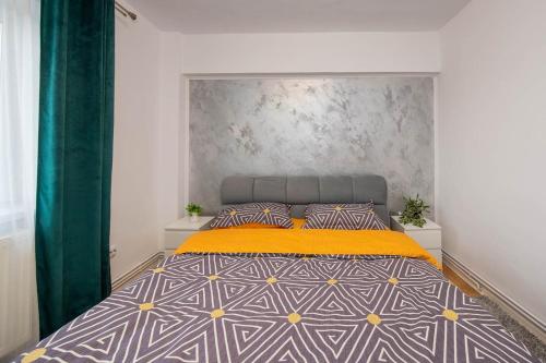a bedroom with a large bed with a yellow blanket at City Center Sanctuary in Braşov