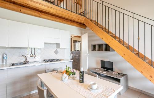 a kitchen with white cabinets and a wooden staircase at Oriental Muti in Chiaramonte Gulfi