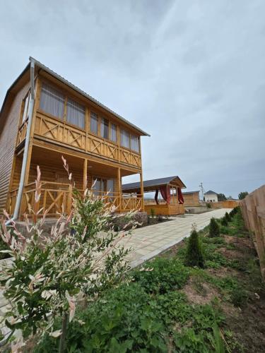 una casa de madera con una pasarela de madera delante de ella en WooD_House_Issyk-Kul en Bosteri