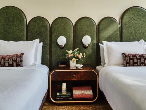a hotel room with two beds and a table between them at The Crawford Hotel in Denver