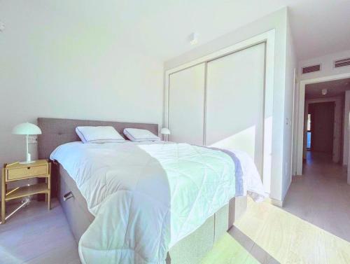 a white bedroom with a large bed with white sheets at Soleil Villamartin Golf in Villamartin