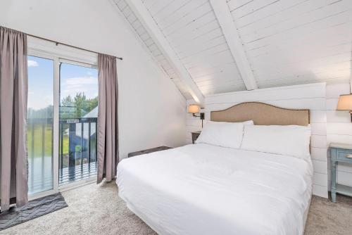 um quarto com uma cama branca e uma grande janela em Tidal House 9 em Ocean Shores